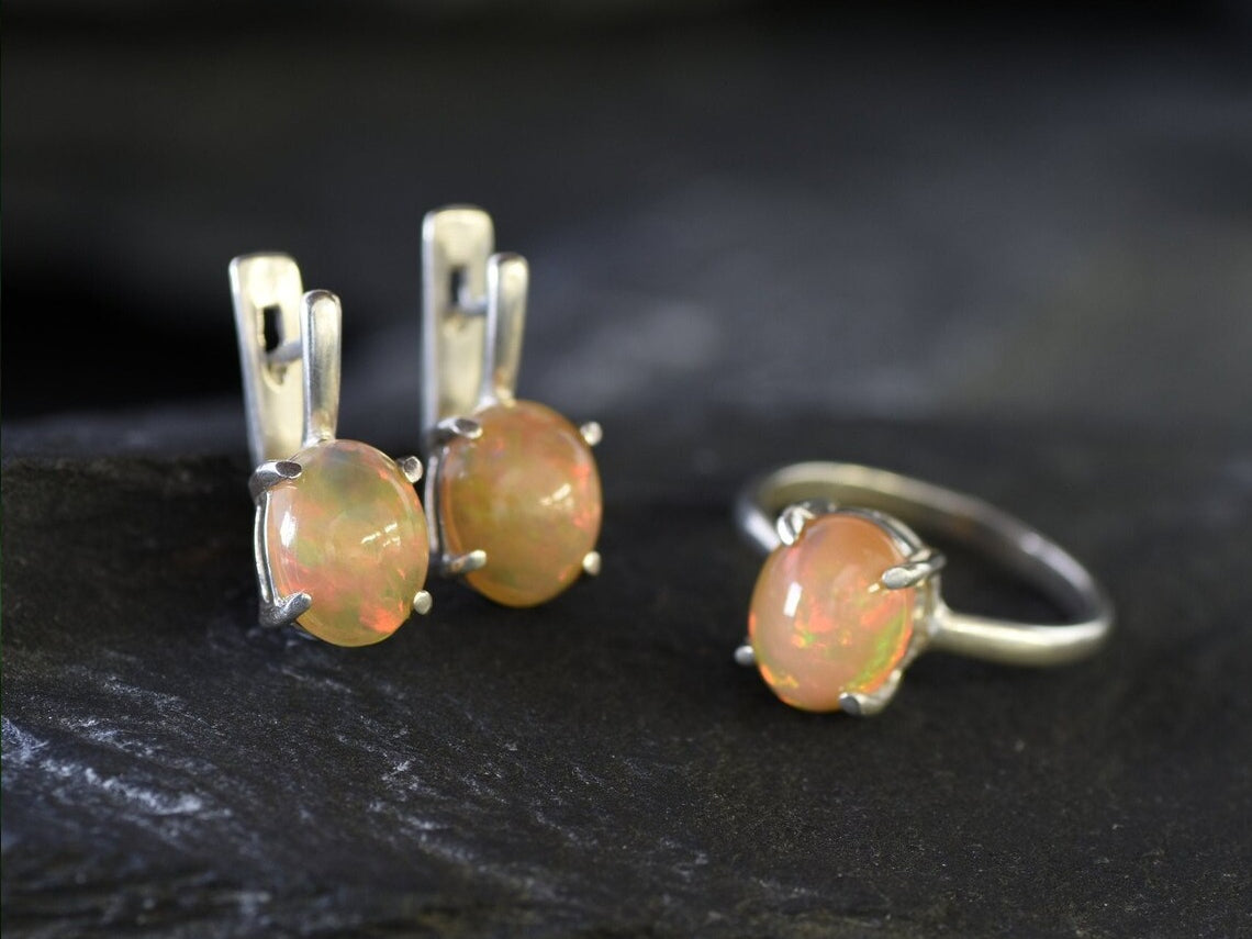 Ethiopian Fire Opal Solitaire Ring in sterling silver with a cabochon cut oval stone showing flashes of fire colors. Opal is linked to creativity, inspiration, and emotional balance, making it a meaningful October birthstone gift. A thoughtful choice for birthdays, anniversaries, promise rings, or engagements. Suitable for daily wear, weddings, and classic elegant occasions.