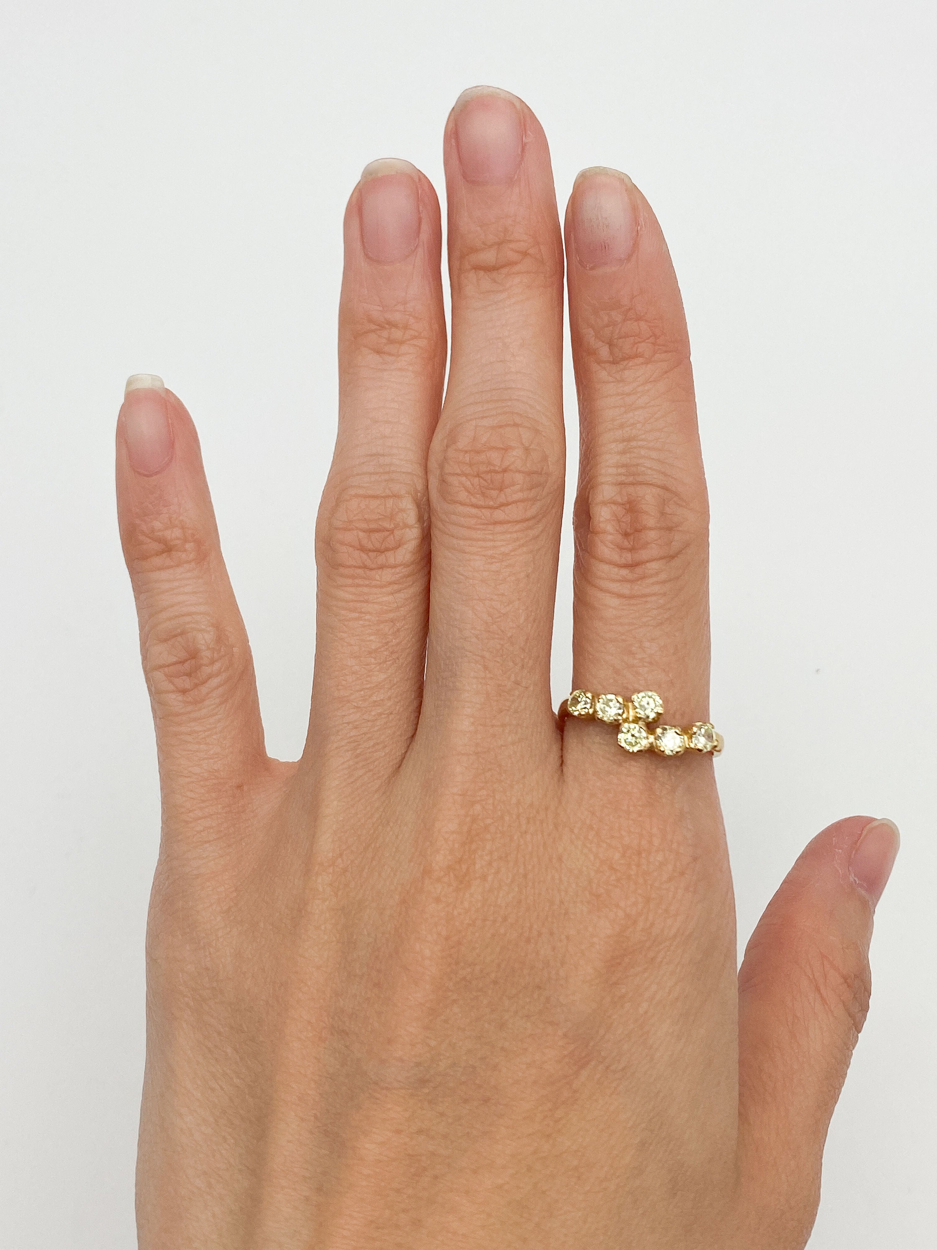Peridot gold ring paired with minimalist accessories, great for professional or casual settings, complementing neutral and warm-toned outfits.