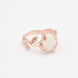 Handcrafted rose gold vine and leaf ring with cabochon white opal featuring flashes of fire colors, offering harmony and renewal, perfect as an October birthstone gift for weddings, anniversaries, or nature-inspired celebrations.