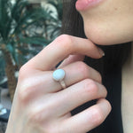 White Opal Bezel Ring paired with sleek hair and minimalist accessories. Jewelry style is timeless solitaire design with a cabochon stone that glows with fire colors and rainbow flashes. Brings emotional balance, clarity, and inspiration. A thoughtful October birthstone gift for anniversaries or birthdays. Perfect for formal dinners, weddings, and everyday elegance.