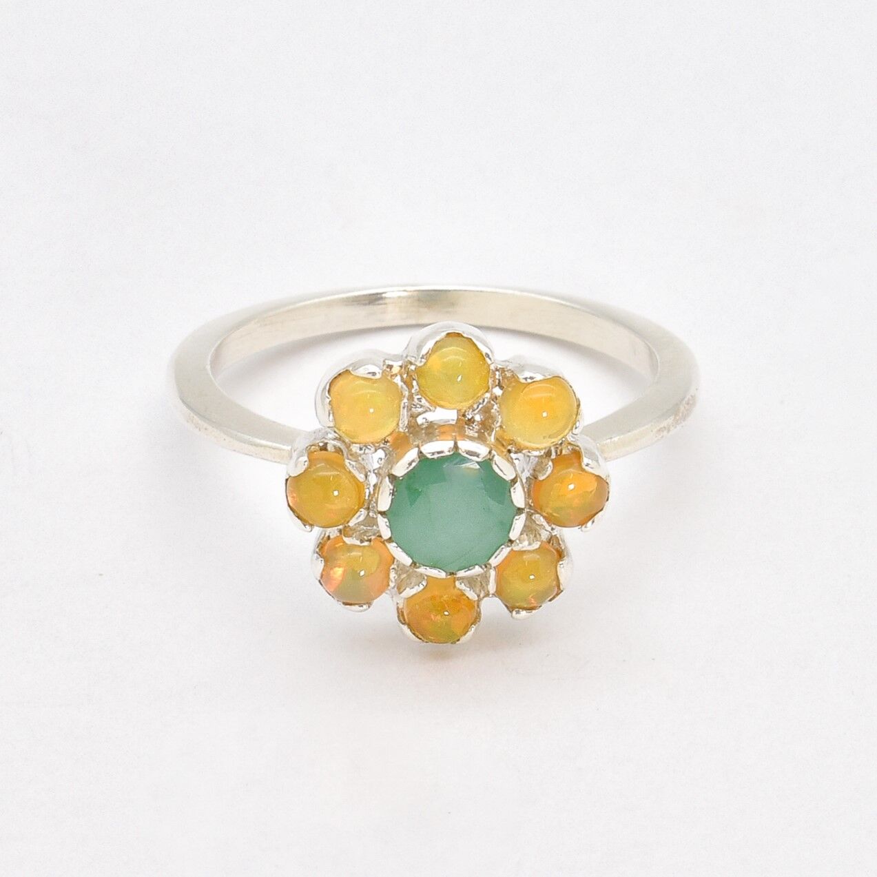 Natural Emerald and Opal Flower Ring in sterling silver with round cabochon opals surrounding a central emerald. Jewelry style is elegant, floral, and artistic with a timeless silver band. Emerald is linked to growth, renewal, and love while Opal is believed to inspire creativity and balance. A meaningful May or Birthstone birthstone gift for birthdays, anniversaries, or special celebrations. Ideal for weddings, garden parties, formal gatherings, or daily elegance.