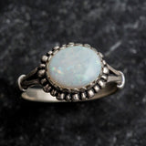 Australian Opal Ring in sterling silver with a horizontal oval cabochon design, white stone showing flashes of fire colors, delicate jewelry style for everyday elegance, meaningful October birthstone gift idea. Perfect for weddings, anniversaries, cocktail parties, and milestone events.