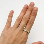 Sterling silver peridot band ring paired with minimalistic accessories, great for daytime wear or professional settings, complementing neutral or earth-toned outfits.