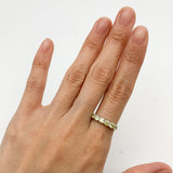 Sterling silver peridot band ring paired with minimalistic accessories, great for daytime wear or professional settings, complementing neutral or earth-toned outfits.