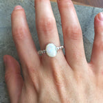 White Opal Bubble Band Ring worn on middle finger with bare nails, great for promoting emotional balance and creativity, suited for casual outings or art events.