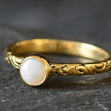 Bezel Opal ring with engraved gold band in a tribal boho style. The opal displays fire colors and flashing rainbow tones, symbolizing hope, creativity and emotional balance. A unique October birthstone gift perfect for anniversaries, festivals, weddings and special celebrations.