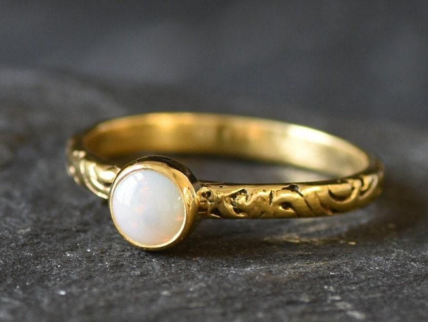 Bezel Opal ring with engraved gold band in a tribal boho style. The opal displays fire colors and flashing rainbow tones, symbolizing hope, creativity and emotional balance. A unique October birthstone gift perfect for anniversaries, festivals, weddings and special celebrations.