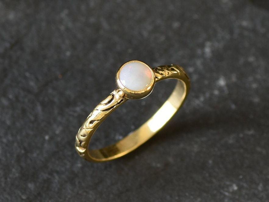 Bezel Opal ring with engraved gold band in a tribal boho style. The opal displays fire colors and flashing rainbow tones, symbolizing hope, creativity and emotional balance. A unique October birthstone gift perfect for anniversaries, festivals, weddings and special celebrations.