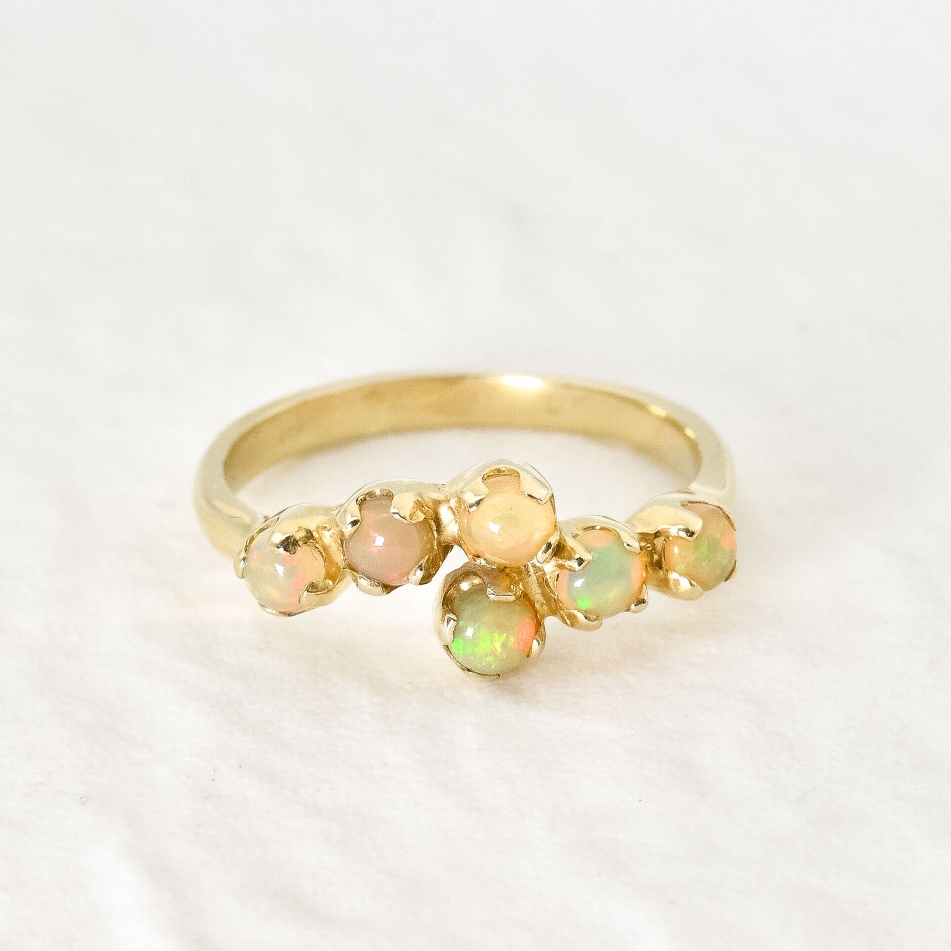 Dainty Opal bypass ring featuring Natural Fire Opals in a gold setting. The bypass design adds elegance and charm while opals are believed to bring hope, inspiration and emotional balance. This makes it a thoughtful October birthstone gift for anniversaries, engagements, weddings and special celebrations.