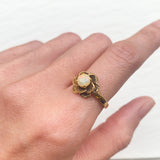 Vintage Opal Flower Ring worn on index finger with bare nails, featuring a rose inspired floral gold setting. Ideal for bringing creativity and emotional balance, perfect for weddings, anniversaries and romantic dinners.  Opal is believed to bring hope, creativity and emotional balance, making it a meaningful October birthstone gift.