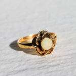 Vintage Fire Opal flower ring with a rose inspired artisan design in gold. The daisy style petals frame a round opal center for a floral and feminine look. Opal is believed to bring hope, creativity and emotional balance, making it a meaningful October birthstone gift. Perfect for weddings, anniversaries, special celebrations and romantic events.