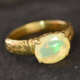 Ethiopian Fire Opal Gold Ring featuring a horizontal oval cut with a secure 4-prong setting. The engraved ornament band adds vintage charm, while the opal displays brilliant flashes of fire colors. A timeless October birthstone ring, perfect for birthdays, anniversaries, weddings, and milestone celebrations.