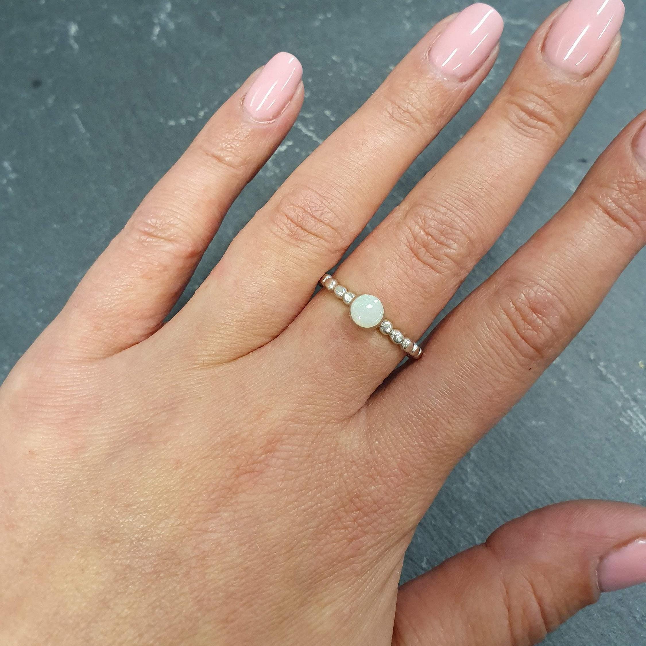 Australian White Opal Ring worn on middle finger with nude pink nails, bezel tennis band design highlighting flashes of fire colors, perfect as an October birthstone for balance and inspiration, ideal for casual outings, workdays, and birthday dinners.