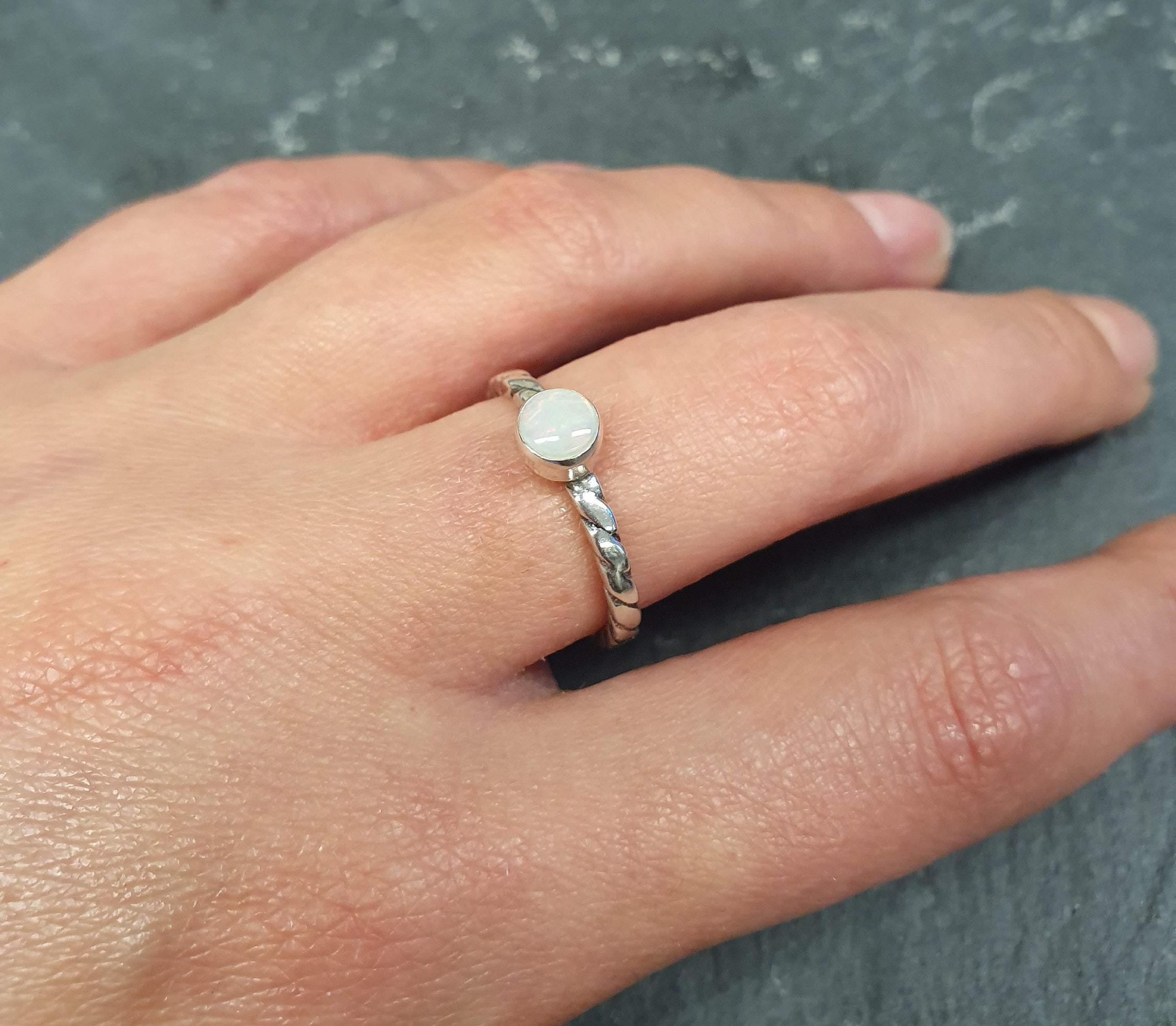 White Opal Solitaire Ring worn on ring finger with nude nails, twisted silver band highlighting flashes of fire colors, perfect as an October birthstone for balance and charm, suitable for date nights, birthdays, and special celebrations.