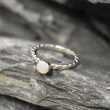 White Opal bezel solitaire ring with round cut stone and twisted band in sterling silver, a timeless jewelry style that highlights flashes of fire colors and durability. Offers the benefit of a secure bezel setting with a refined solitaire look, making it a meaningful October birthstone gift idea. Perfect for birthdays, anniversaries, engagements, and daily wear events.