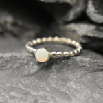 Australian White Opal bezel bubble band ring in sterling silver with round cabochon cut and flashes of fire colors, a chic jewelry style perfect for stacking and minimal elegance. Offers the benefit of a secure bezel set design with playful bubble band details, making it an ideal October birthstone gift. Perfect for birthdays, anniversaries, weddings, or everyday wear.