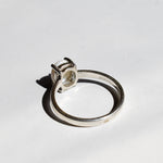 White Opal solitaire ring in sterling silver showcasing flashes of rainbow colors, dainty jewelry style perfect for daily elegance, believed to bring inspiration and emotional balance, a meaningful October birthstone gift idea for anniversaries, engagements, and weddings.