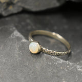 White Opal Bezel Ring with engraved tribal inspired silver band. The dainty minimalist design highlights the gemstone with flashes of color, making it both elegant and unique. Opal is known to bring inspiration, harmony, and emotional balance. A thoughtful promise ring or October birthstone gift for birthdays, anniversaries, and special milestones. Perfect to wear daily or for boho chic events, weddings, and family gatherings.
