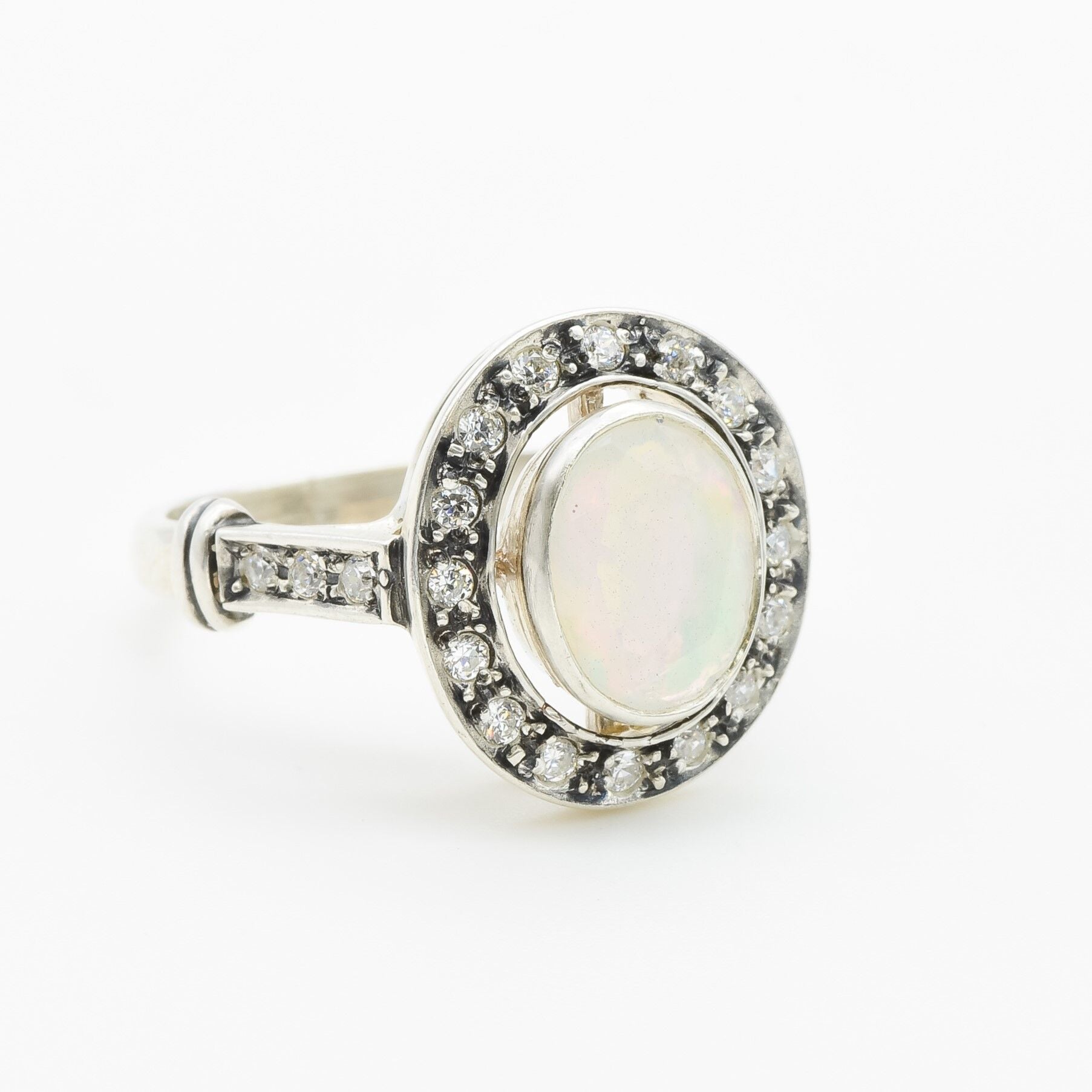 White Opal oval bezel halo ring with Victorian vintage design in solid 925 sterling silver, featuring flashes of fire colors for energy and inspiration, perfect as an October birthstone gift and for engagements, anniversaries, or elegant celebrations.