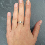 White Opal Ring worn on middle finger with nude nails paired with hammered silver band. Brings creativity and calmness, a meaningful October birthstone gift. Perfect for dinners, anniversaries and special celebrations.