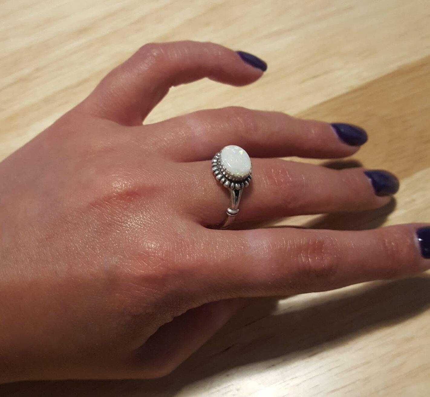 White Australian Opal Ring styled on middle finger with glossy purple manicure, horizontal cabochon cut with subtle fire flashes, elegant October birthstone jewelry that adds charm and balance. Ideal for date nights, gallery visits, and social gatherings