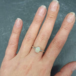 White Opal Solitaire Ring worn on middle finger with bare nails, perfect for daily wear bringing emotional healing and clarity, a thoughtful October birthstone gift for birthdays and engagements.