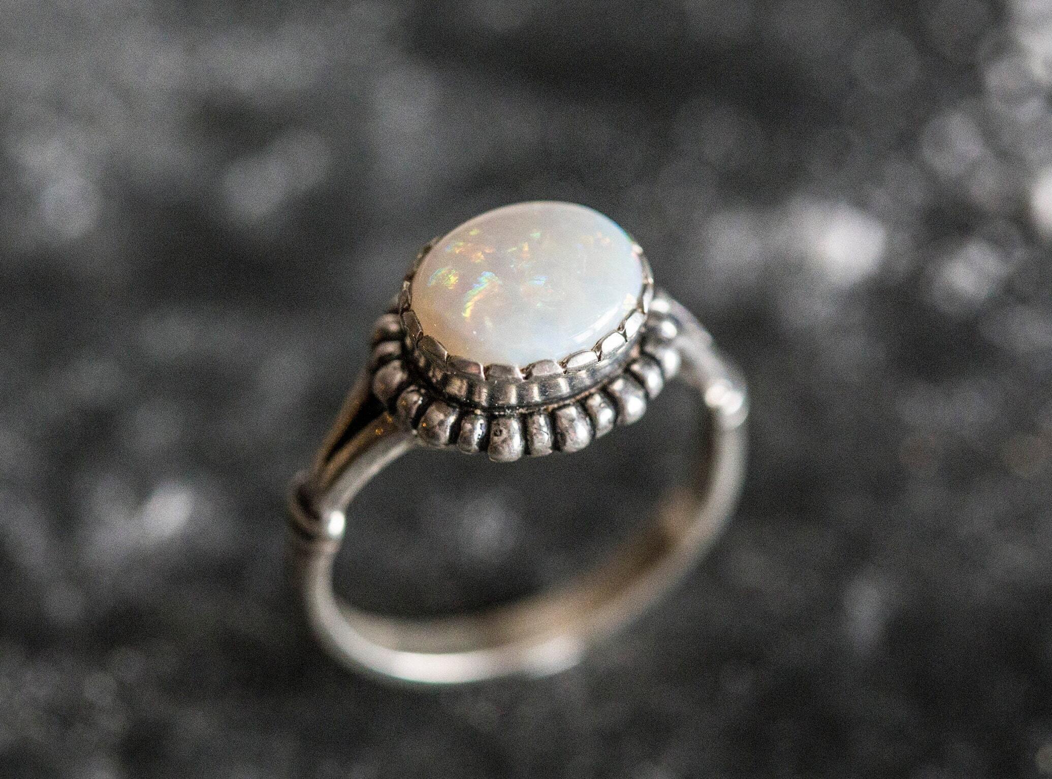 Australian Opal Ring in sterling silver with a horizontal oval cabochon design, white stone showing flashes of fire colors, delicate jewelry style for everyday elegance, meaningful October birthstone gift idea. Perfect for weddings, anniversaries, cocktail parties, and milestone events.