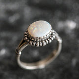 Australian Opal Ring in sterling silver with a horizontal oval cabochon design, white stone showing flashes of fire colors, delicate jewelry style for everyday elegance, meaningful October birthstone gift idea. Perfect for weddings, anniversaries, cocktail parties, and milestone events.