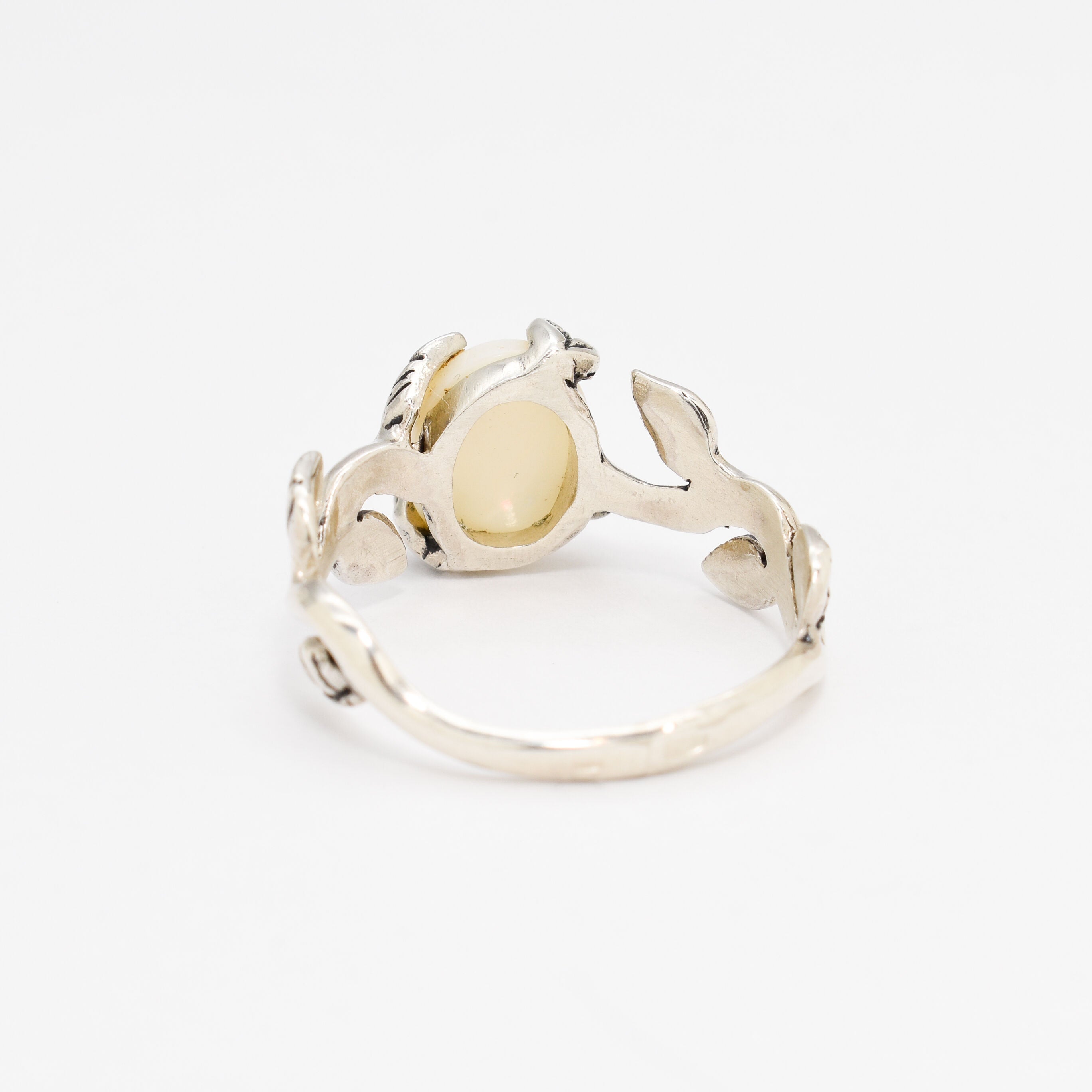 White Opal cabochon vine and leaf ring crafted in solid 925 sterling silver, featuring a nature-inspired design with flashes of fire colors. The durable vine-style band offers elegance and uniqueness while remaining comfortable for daily wear. As the October Birthstone, White Opal makes a thoughtful gift for birthdays, anniversaries, and nature lovers. Perfect to wear at weddings, outdoor celebrations, and festive gatherings.