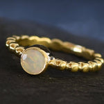 Yellow Fire Opal Bubble Band Ring in gold with bezel set round cut, showcasing flashes of fire colors in a tennis band design for an elegant jewelry style. This durable and timeless piece is a meaningful October birthstone gift idea, symbolizing passion and inspiration. Ideal for birthdays, weddings, anniversaries, and evening occasions where a touch of unique brilliance is desired.