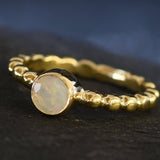 Yellow Fire Opal Bubble Band Ring in gold with bezel set round cut, showcasing flashes of fire colors in a tennis band design for an elegant jewelry style. This durable and timeless piece is a meaningful October birthstone gift idea, symbolizing passion and inspiration. Ideal for birthdays, weddings, anniversaries, and evening occasions where a touch of unique brilliance is desired.