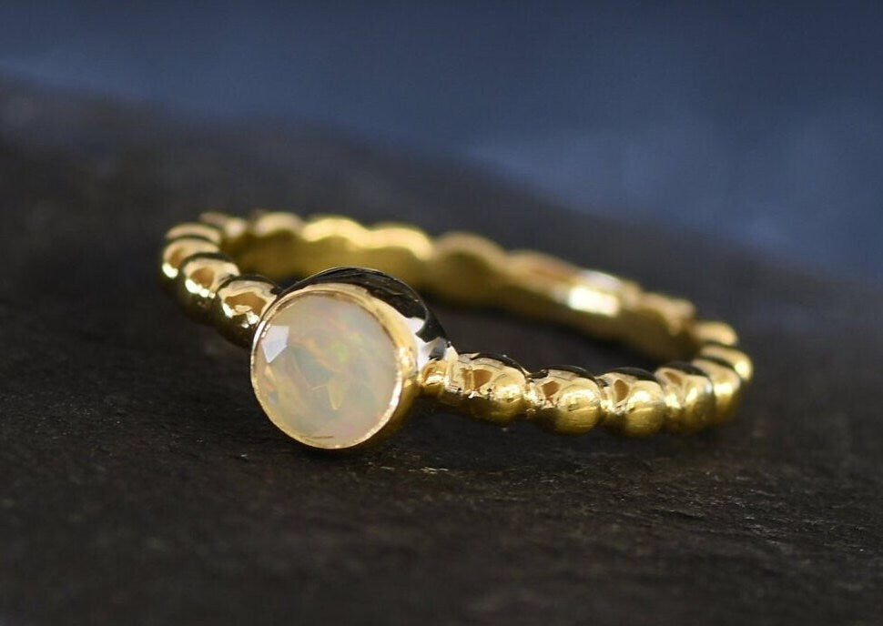 Yellow Fire Opal Bubble Band Ring in gold with bezel set round cut, showcasing flashes of fire colors in a tennis band design for an elegant jewelry style. This durable and timeless piece is a meaningful October birthstone gift idea, symbolizing passion and inspiration. Ideal for birthdays, weddings, anniversaries, and evening occasions where a touch of unique brilliance is desired.