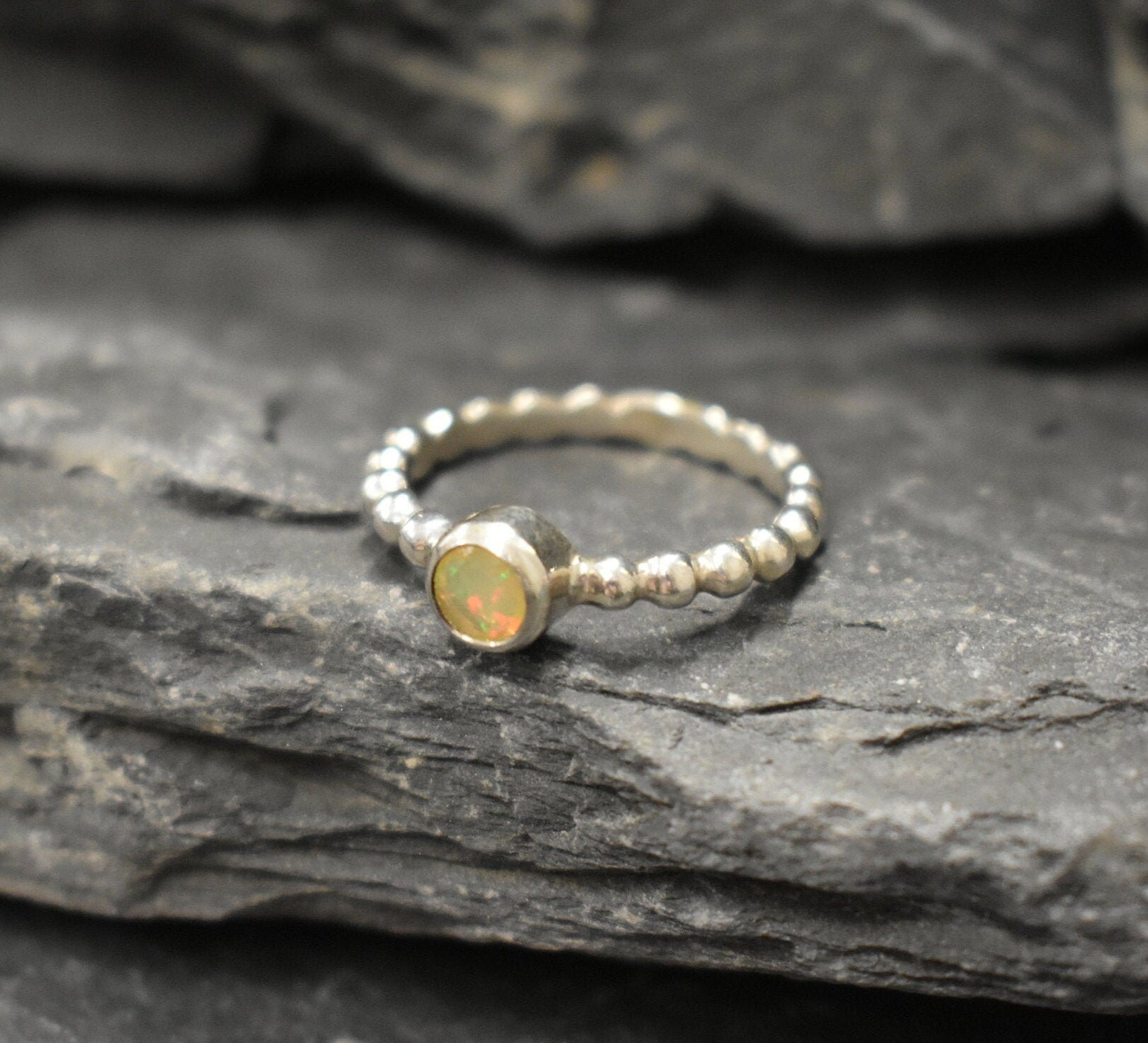 Yellow Fire Opal Bubble Band Ring in sterling silver with bezel set round cut, showcasing flashes of fire colors in a tennis band design for an elegant jewelry style. This durable and timeless piece is a meaningful October birthstone gift idea, symbolizing passion and inspiration. Ideal for birthdays, weddings, anniversaries, and evening occasions where a touch of unique brilliance is desired.