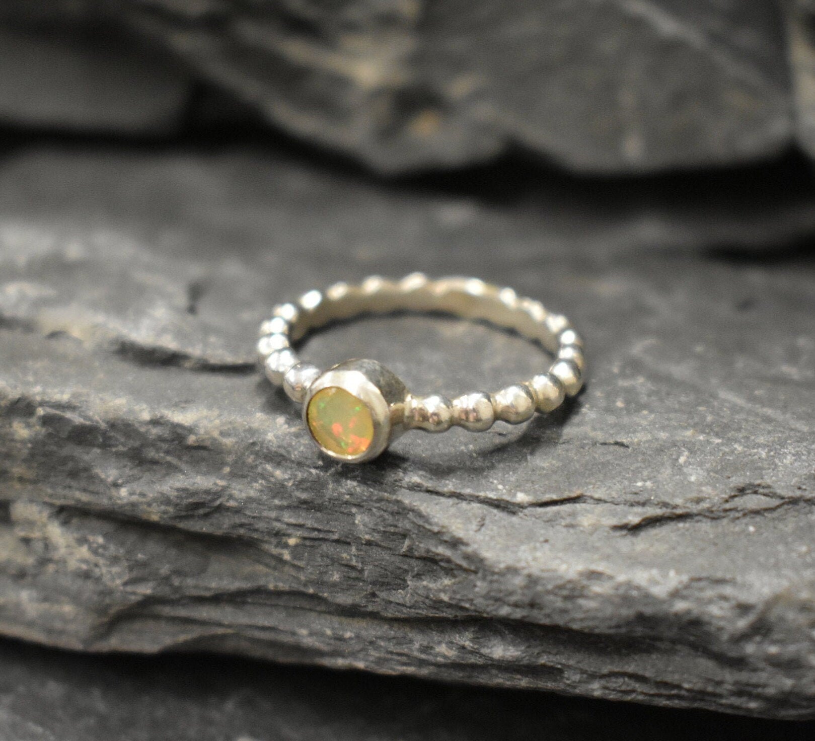 Yellow Fire Opal Bubble Band Ring in sterling silver with bezel set round cut, showcasing flashes of fire colors in a tennis band design for an elegant jewelry style. This durable and timeless piece is a meaningful October birthstone gift idea, symbolizing passion and inspiration. Ideal for birthdays, weddings, anniversaries, and evening occasions where a touch of unique brilliance is desired.