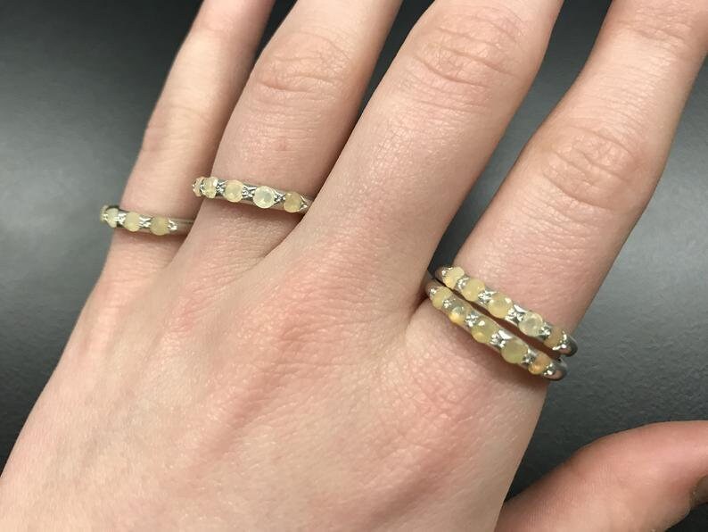 Yellow Ethiopian Fire Opal half eternity band ring in sterling silver with diamond cut stones set in a row, showcasing flashes of fire colors in a dainty jewelry style. Offers the benefit of a sleek eternity design with bright opals for durability and charm, making it a meaningful October birthstone gift. Perfect for weddings, anniversaries, birthdays, and daily wear.