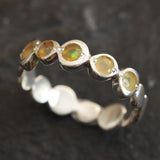 Yellow Ethiopian Fire Opal bezel tennis band eternity ring in sterling silver with diamond cut stones showing flashes of fire colors, a stylish jewelry design with bubble band details. Provides the benefit of a secure bezel setting and continuous gemstone glow, making it a meaningful October birthstone gift. Perfect for weddings, anniversaries, birthdays, and everyday wear.