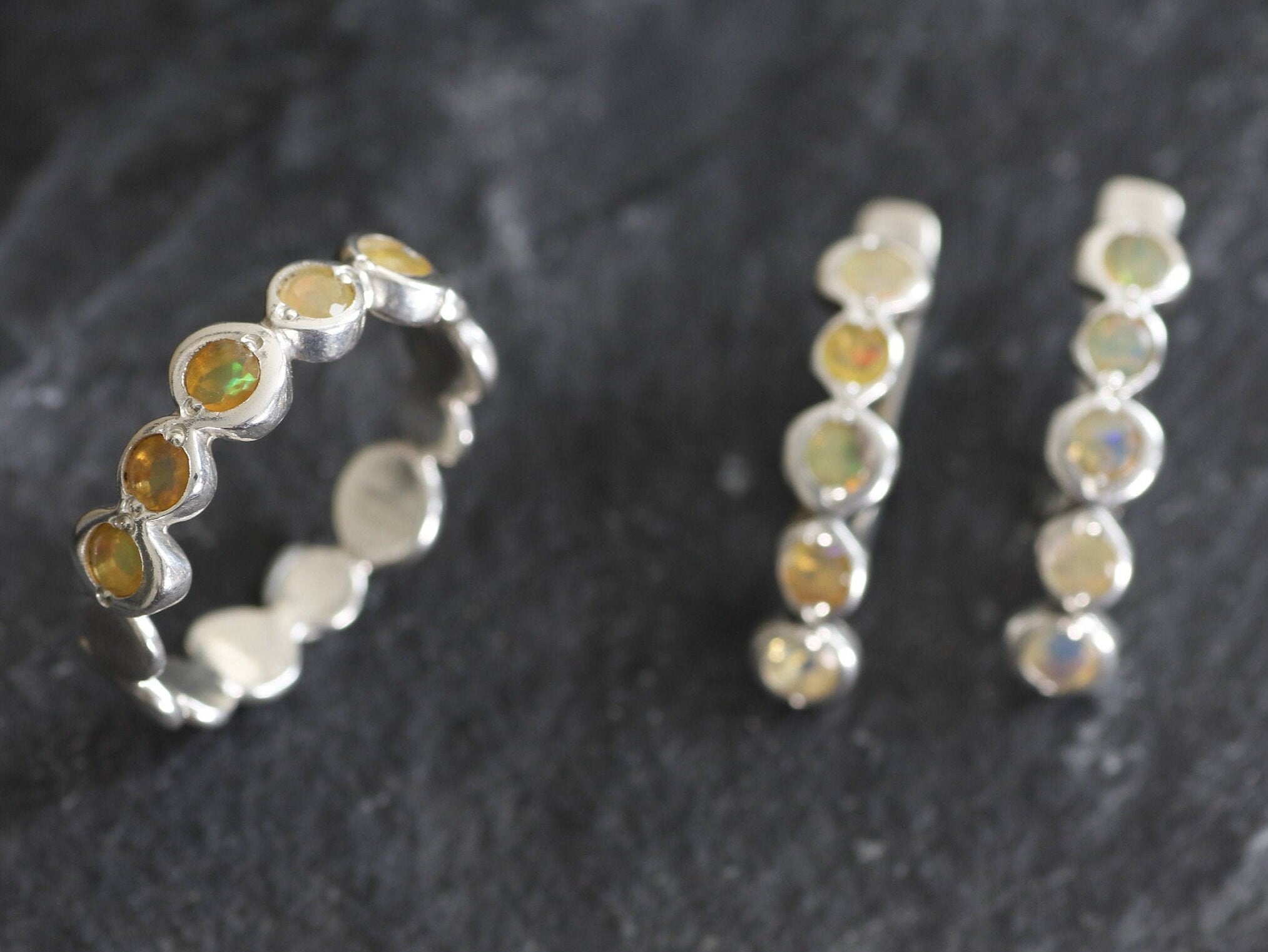 Yellow Ethiopian Fire Opal bezel tennis band eternity ring in sterling silver with diamond cut stones showing flashes of fire colors, a stylish jewelry design with bubble band details. Provides the benefit of a secure bezel setting and continuous gemstone glow, making it a meaningful October birthstone gift. Perfect for weddings, anniversaries, birthdays, and everyday wear.