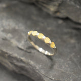 Yellow Ethiopian Fire Opal half eternity band ring in sterling silver with diamond cut stones set in a row, showcasing flashes of fire colors in a dainty jewelry style. Offers the benefit of a sleek eternity design with bright opals for durability and charm, making it a meaningful October birthstone gift. Perfect for weddings, anniversaries, birthdays, and daily wear.