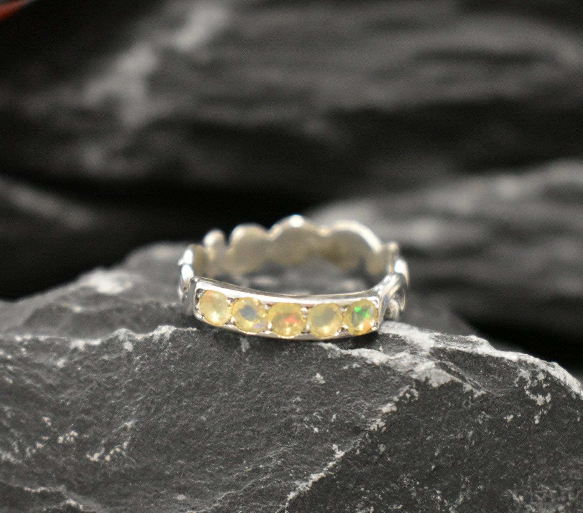Yellow Ethiopian Opal row ornament band ring in sterling silver with round cut stones showcasing flashes of fire colors, a dainty jewelry style with timeless elegance. Offers the benefit of a lightweight, comfortable band with radiant opals, making it a meaningful October birthstone gift. Ideal for birthdays, anniversaries, weddings, and everyday wear.