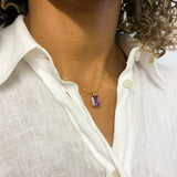 Woman wearing 18k yellow gold plated necklace with Amethyst February birthstone, in radiant cut and prong setting. Solitaire necklace for peace, clarity, intuition