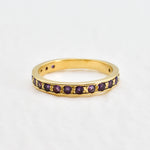 Front view of amethyst gold ring showcasing sparkling purple diamond cut stones