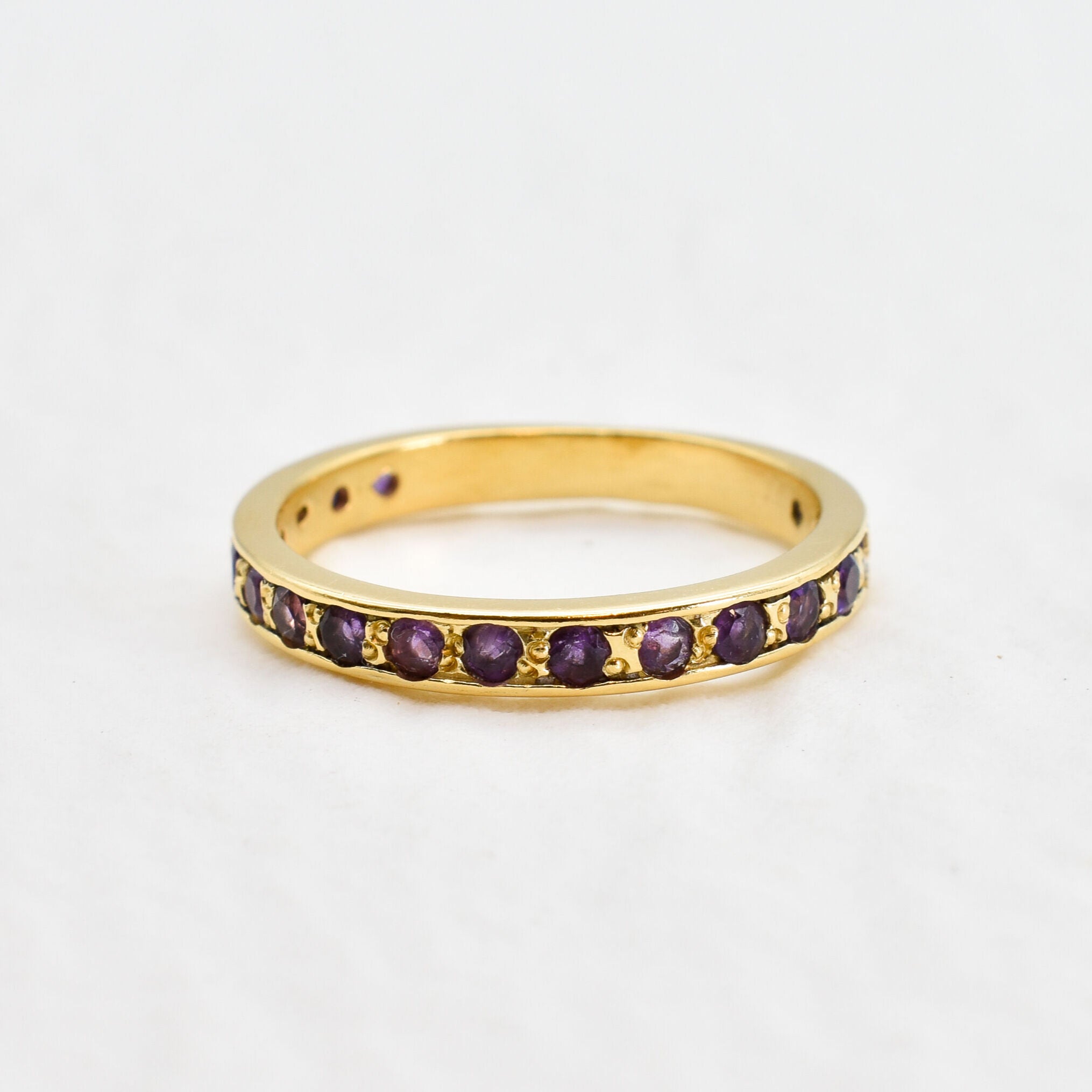 Front view of amethyst gold ring showcasing sparkling purple diamond cut stones