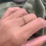 Woman wearing amethyst gold ring showing vibrant purple stones on finger