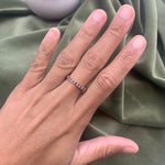 Close-up of amethyst gold ring worn on hand showing purple stones and elegant band design