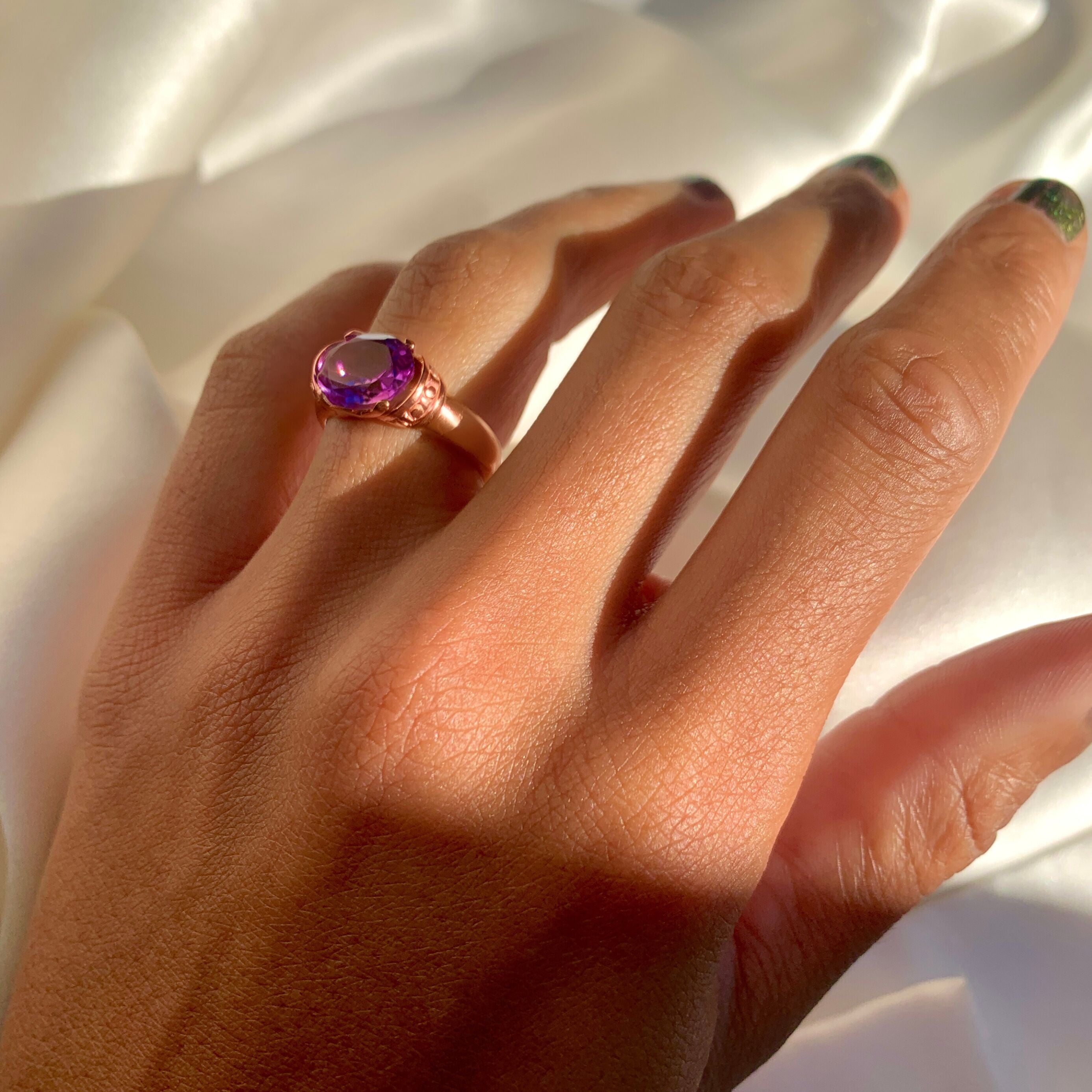 Woman wearing rose gold amethyst ring showing purple gemstone and elegant band
