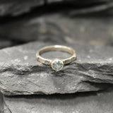 Minimalist hammered band with cool blue Aquamarine, perfect for work looks or calming benefits.