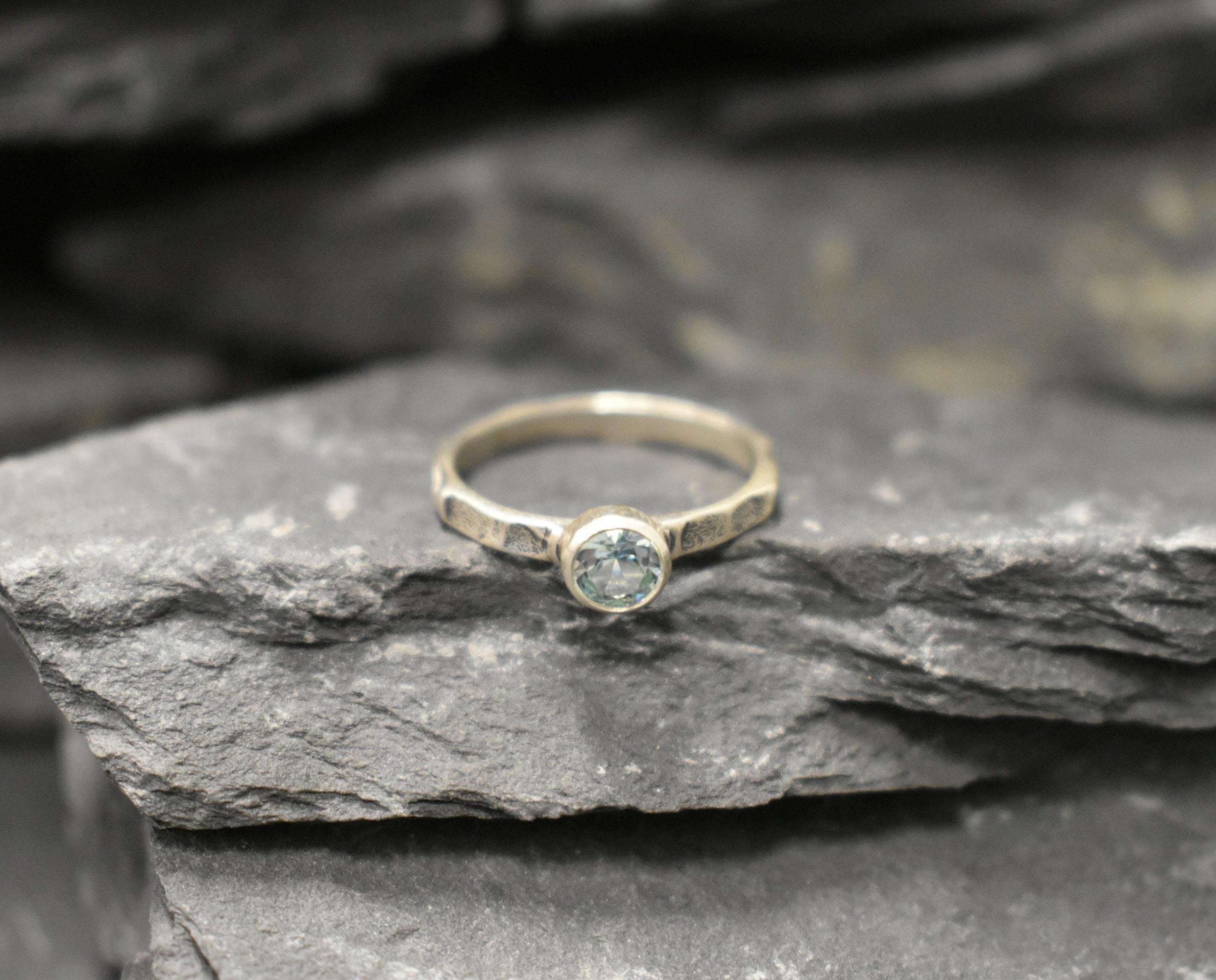 Minimalist hammered band with cool blue Aquamarine, perfect for work looks or calming benefits.