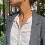 Model wearing black onyx pendant necklace styled with blazer jacket for sophisticated vintage jewelry look