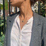 Model wearing black onyx pendant necklace styled with blazer jacket for sophisticated vintage jewelry look