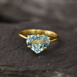 Front profile view of blue topaz heart gold ring highlighting gemstone brilliance and gold band craftsmanship